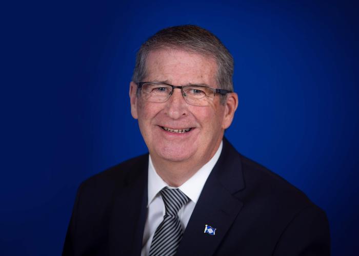 A photo of a man with a blue background