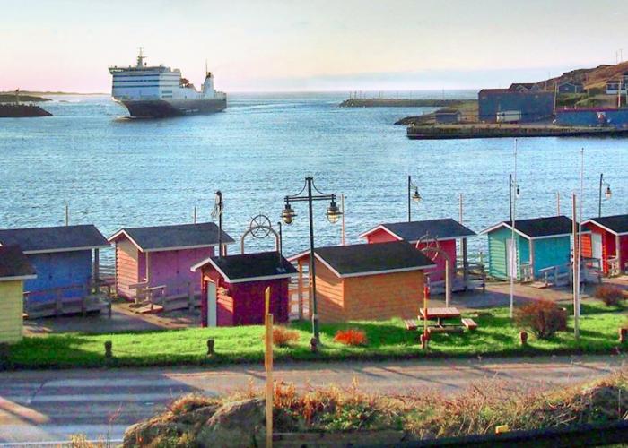 View of Scott's Cove colourful buildings with ferry in the background