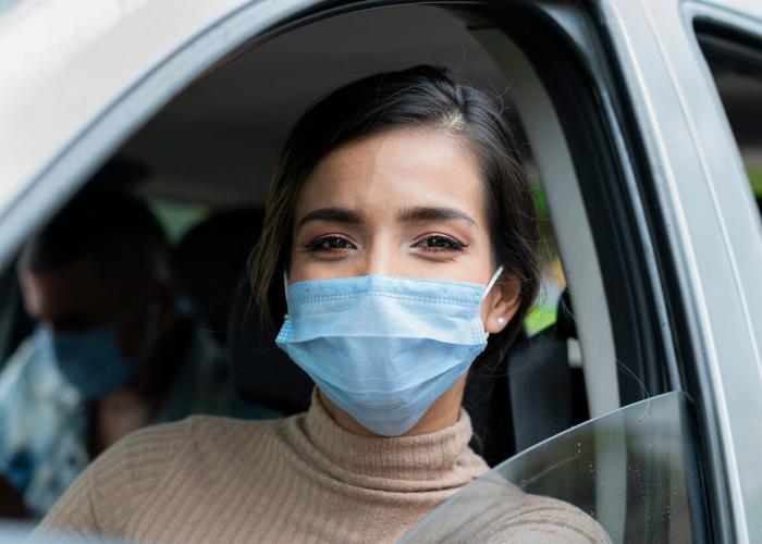 woman wearing blue mask while sitting in the car