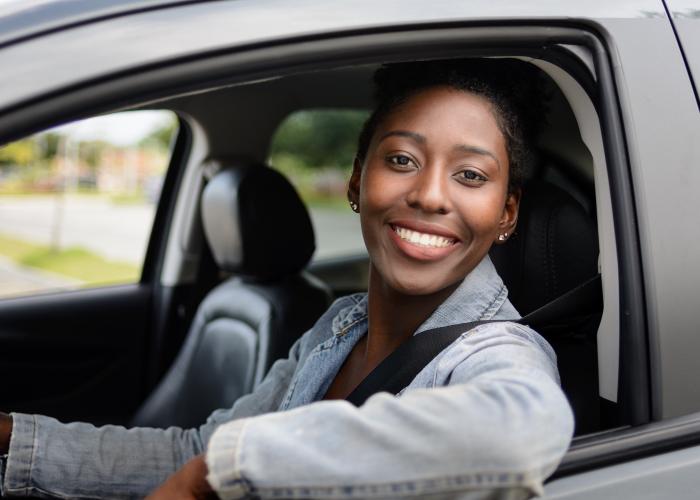 a woman sitting in her car smiling at the camera