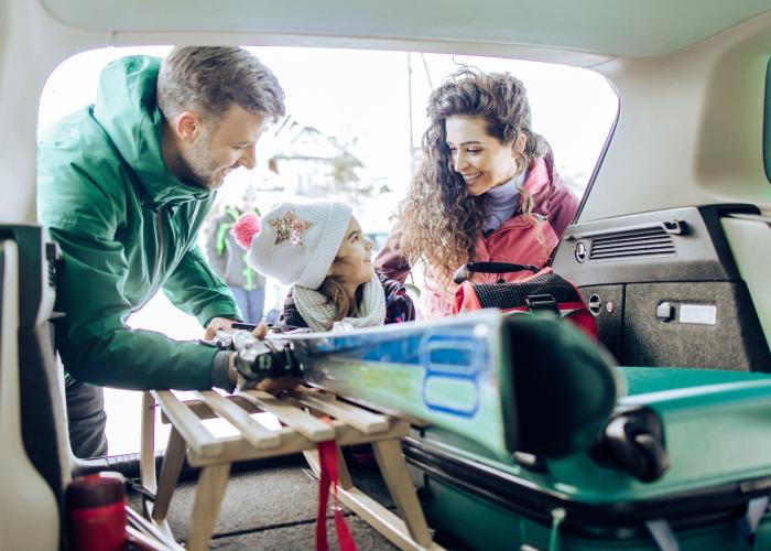 Couple and child packing up car for holidays