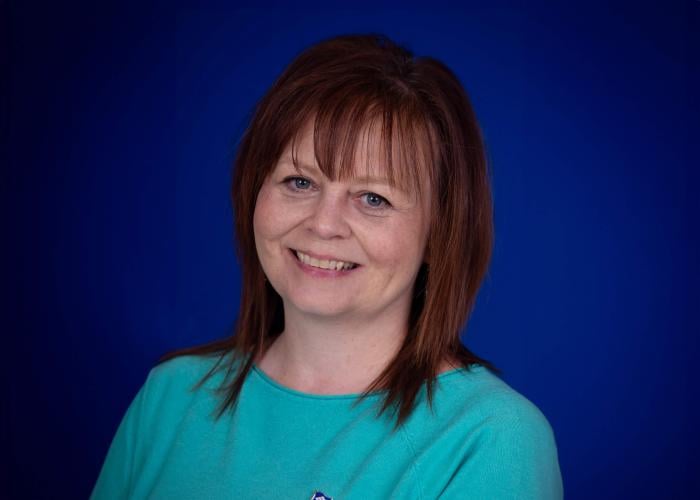 A photo of a woman in front of a blue background