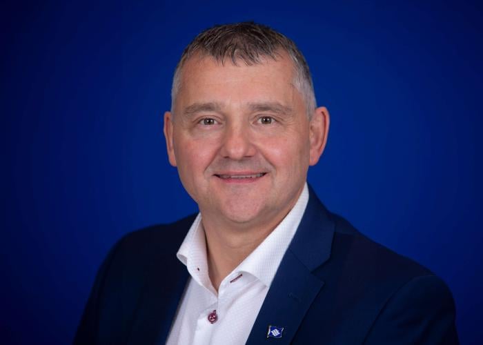 A photo of a man with a blue background