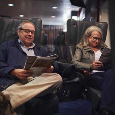 Two people sitting in their seats reading