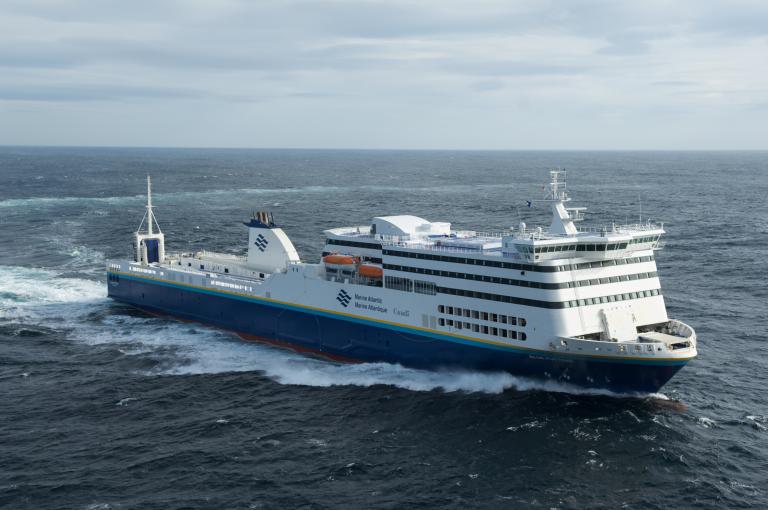 The Marine Atlantic MV Blue Puttees ferry sails the whitecaps of the Atlantic Ocean on a clear but windy day. 