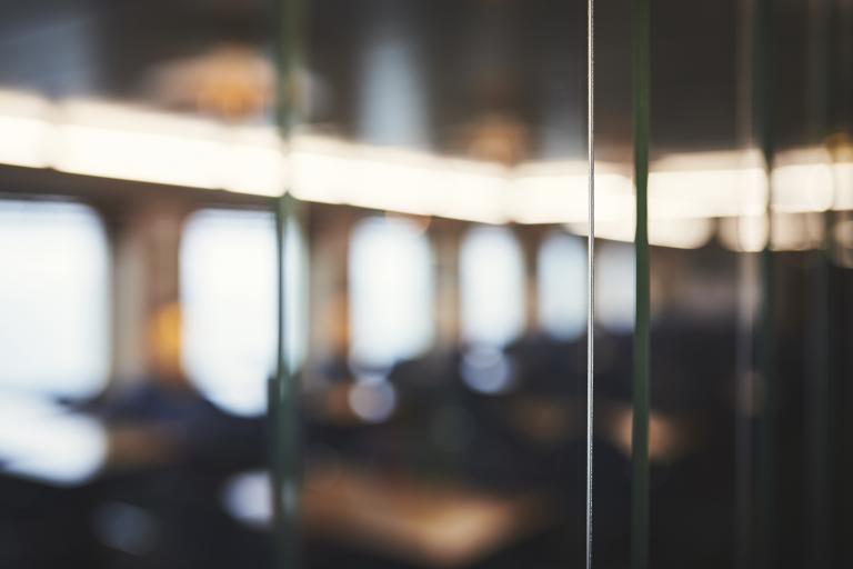 A blurry, unfocused image of a window overlooking what might be a seating area inside a Marine Atlantic ferry.