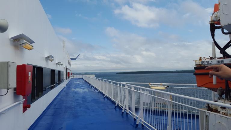 Image: top deck of a vessel, ocean view in the background.