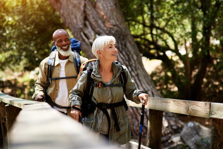 a couple hikes across a bridge in wooded area