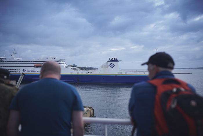 people stand at a railing looking out to a Marine Atlantic Ferry