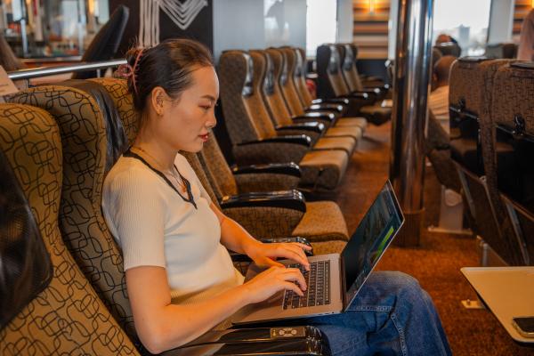 Person sitting in recliner seat typing on laptop computer